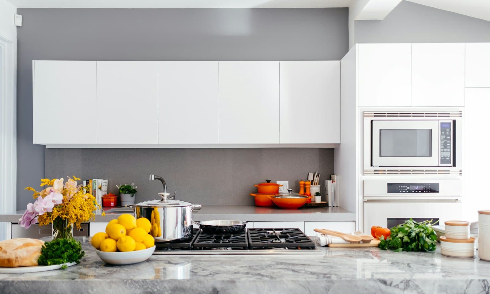 A bright modern kitchen with a built-in microwave, oven and cooktop