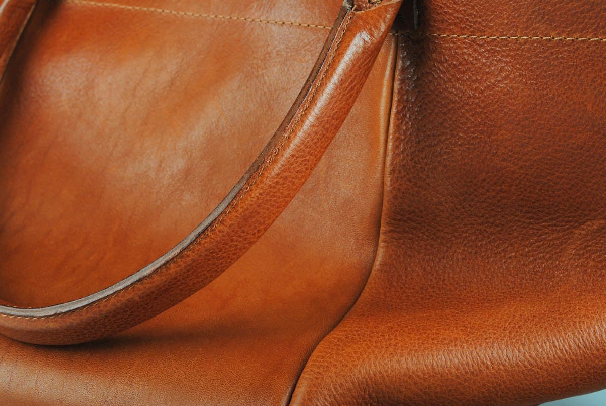 Close-up of rust-coloured full-grain leather with a curved edge