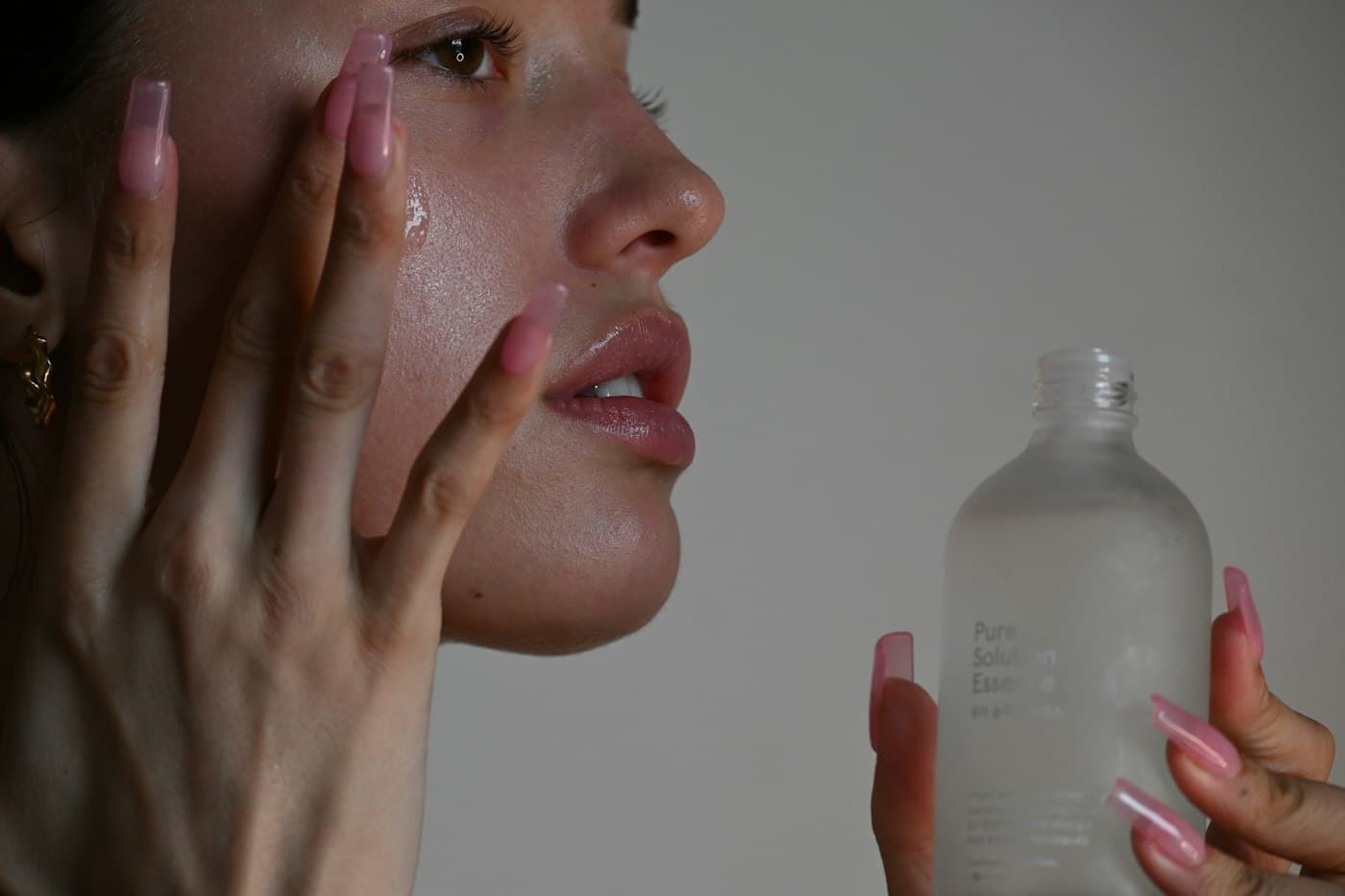 A woman smoothing serum onto her cheek