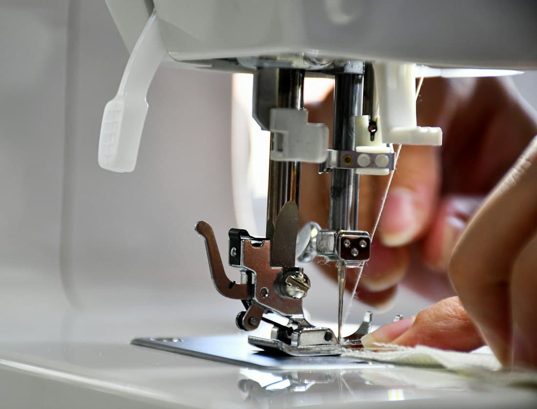 Hands guiding fabric through a sewing machine