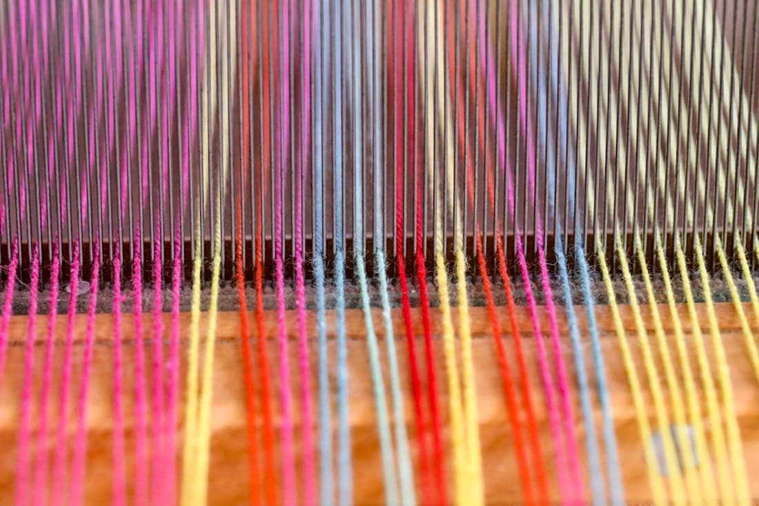Colourful warp threads stretched across a loom