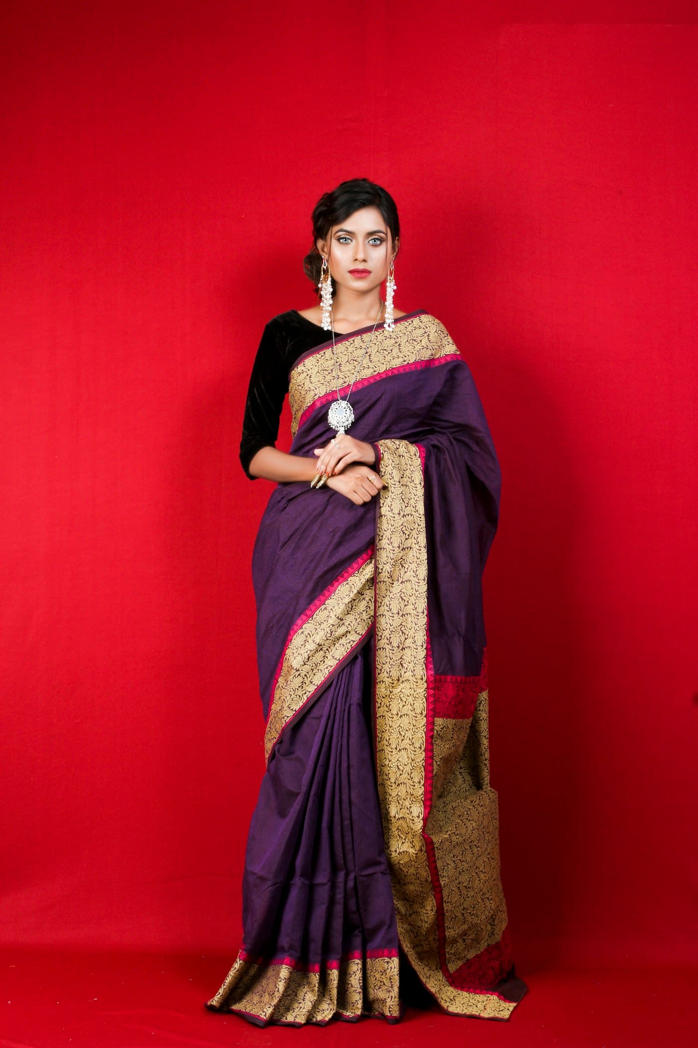 Woman in a maroon gold-border saree