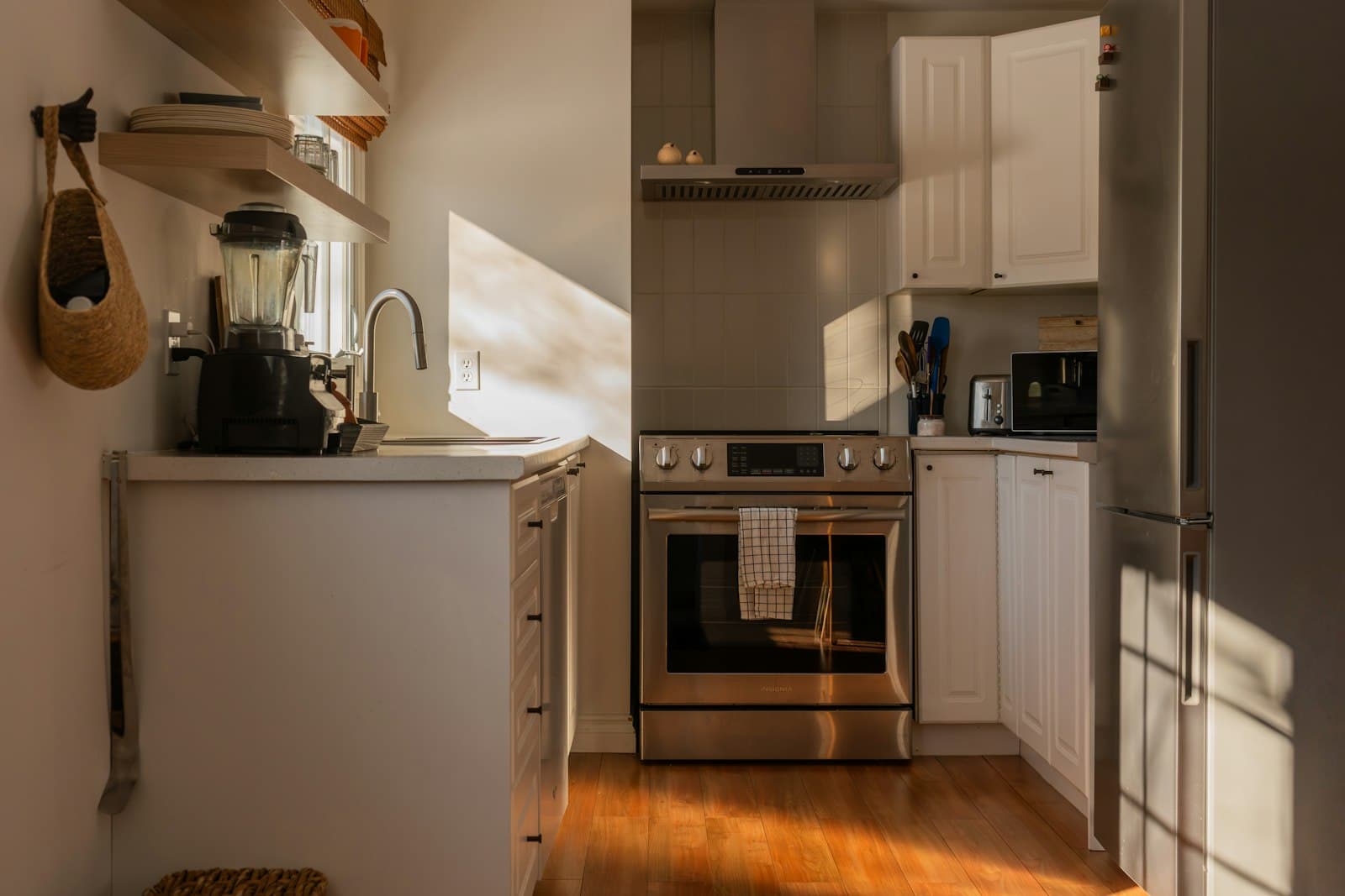 Sunlit kitchen with wooden floor and steel appliances