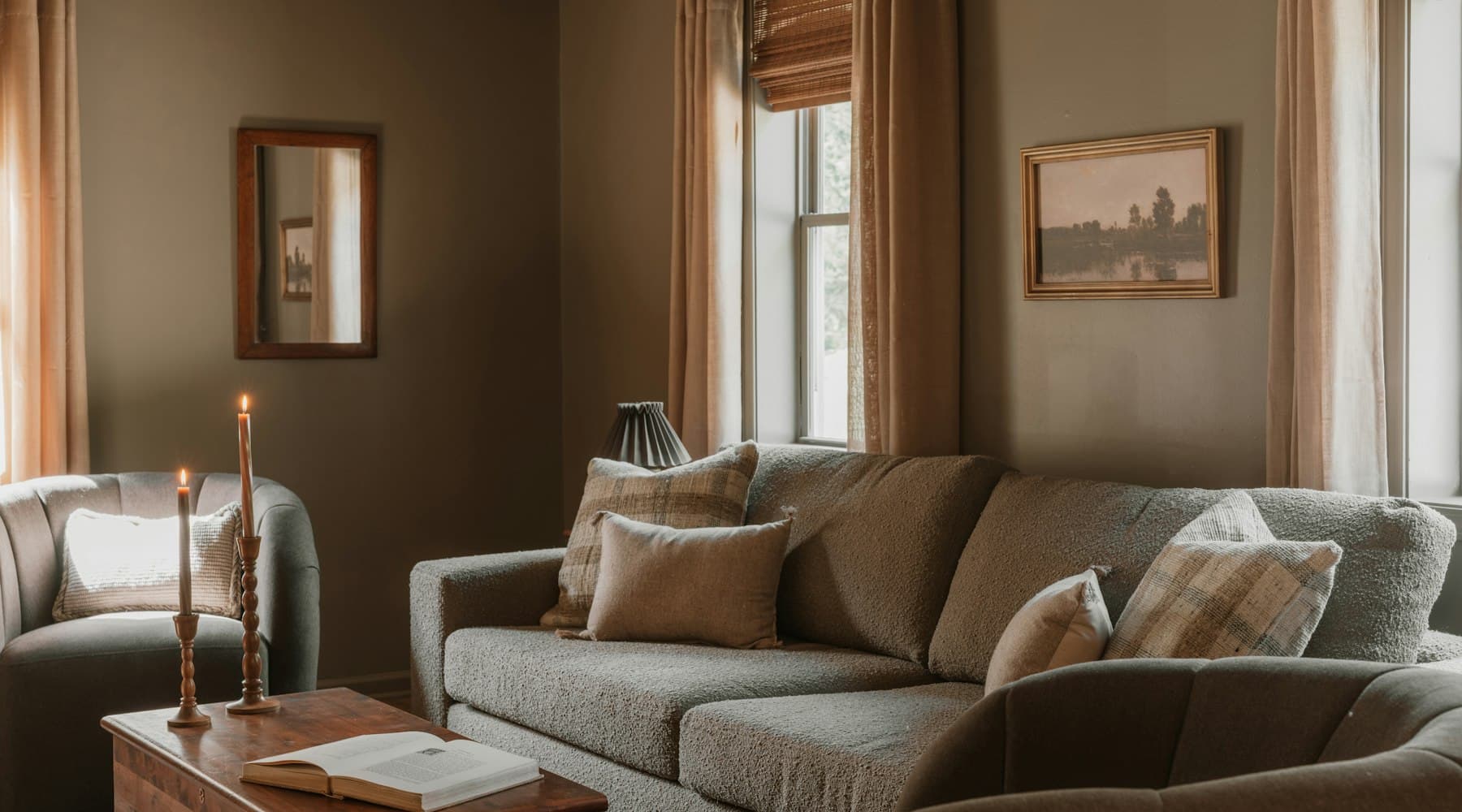 A calm living room with a grey sofa, linen curtains and cushions