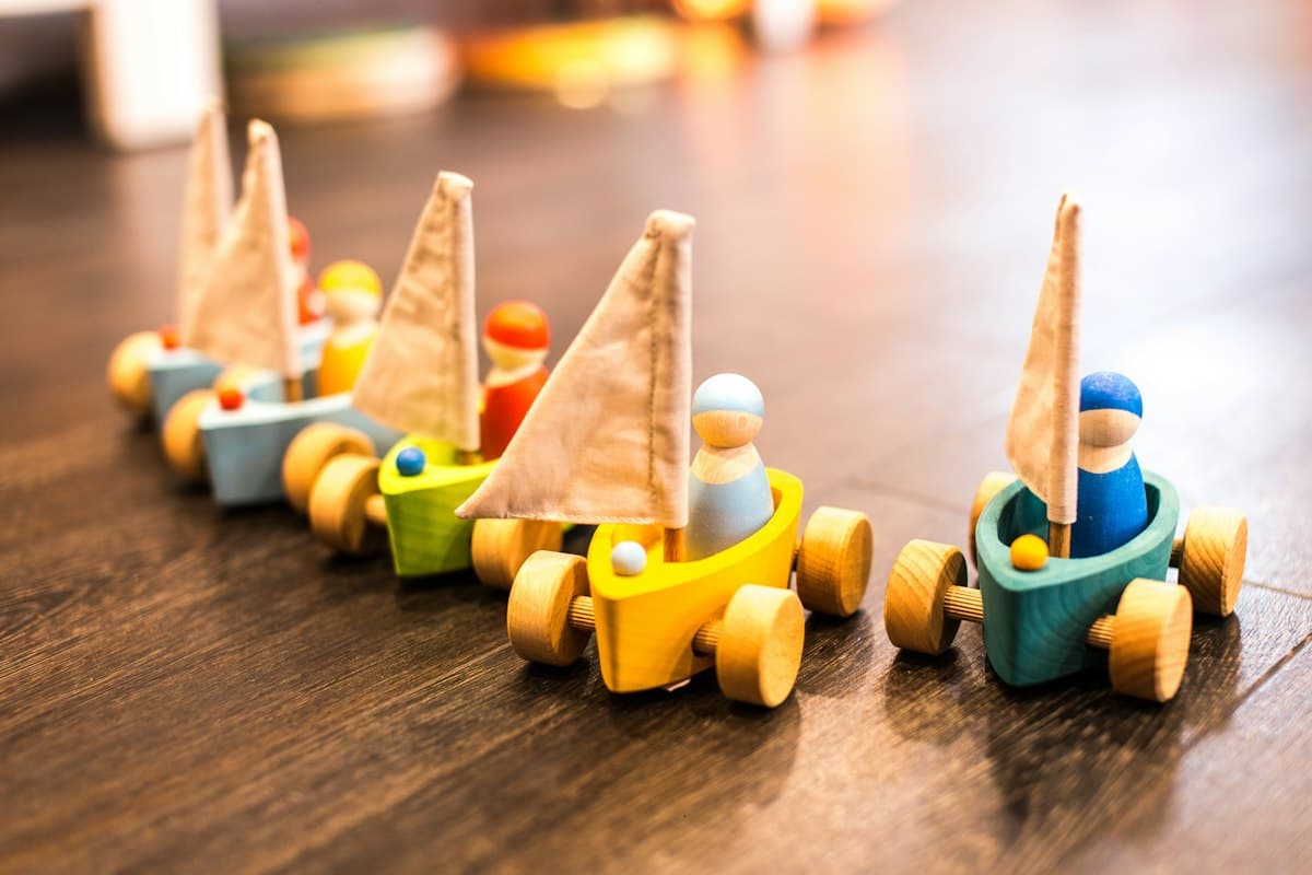 Wooden toy boats with peg figures on a table
