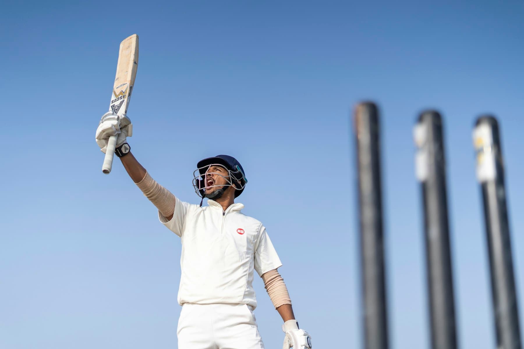 A batsman raising his bat after reaching a century